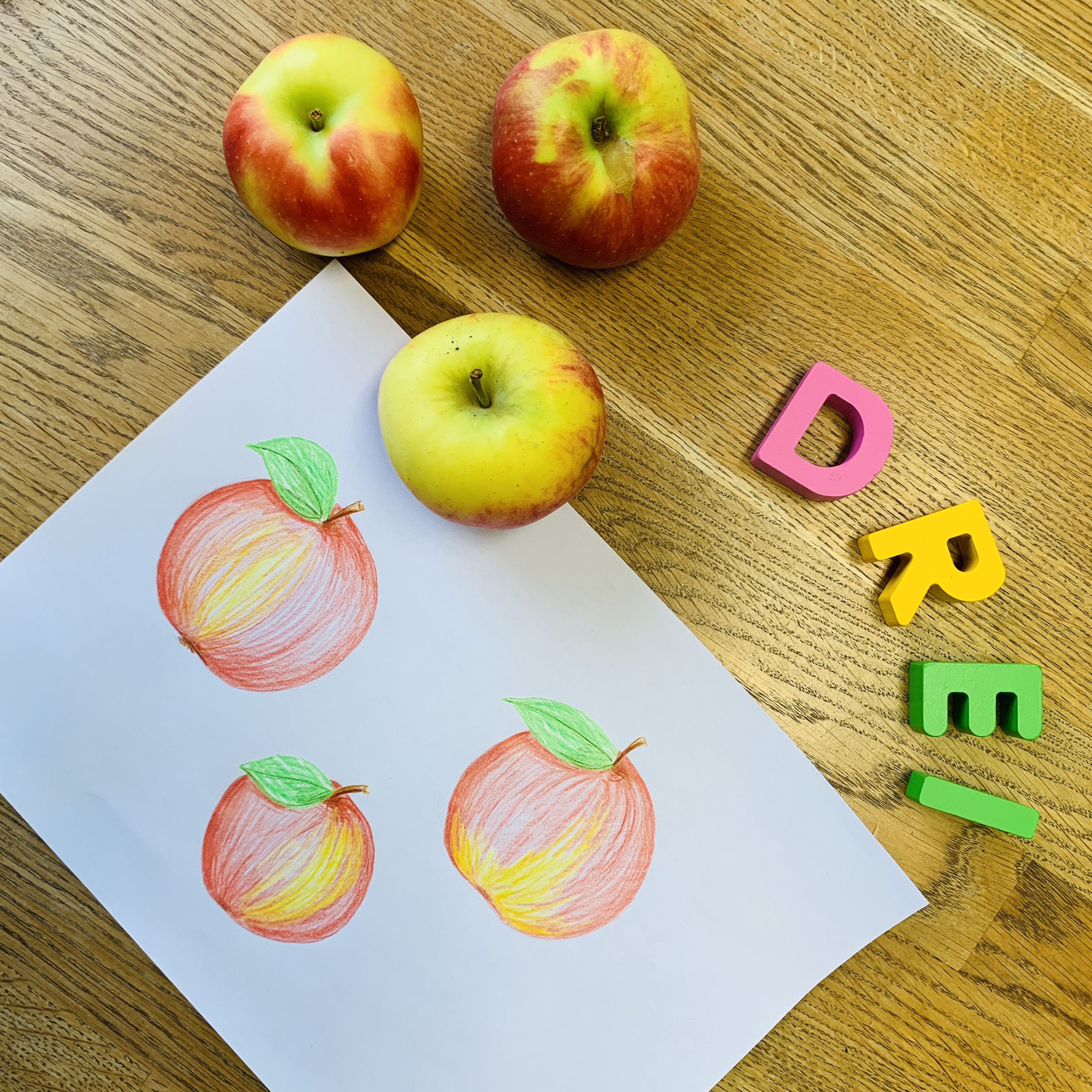 Dyskalkulie: Zahl 3 visualisiert durch Äpfel, Schrift und Porträt